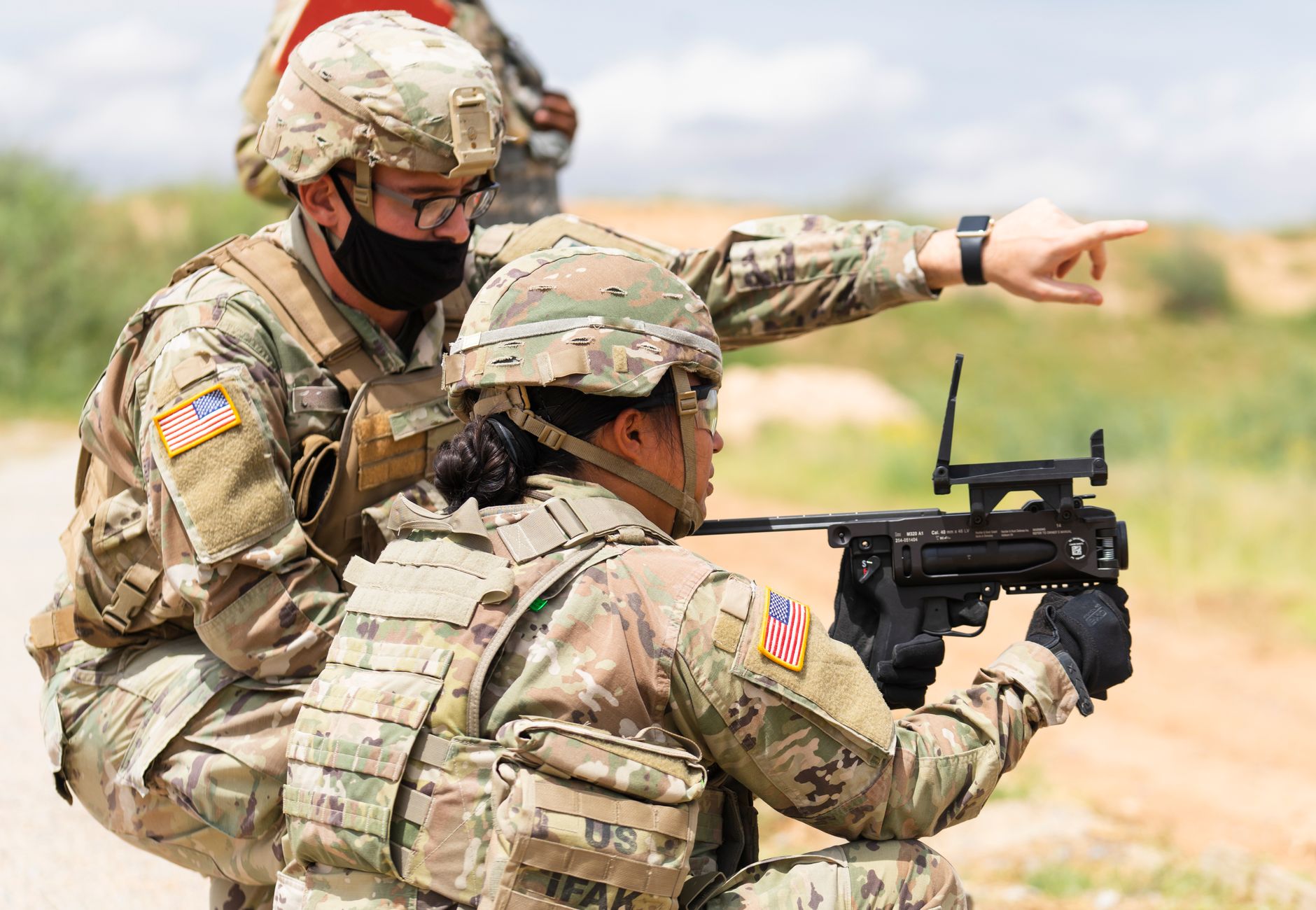 Two US soldiers engage in outdoor combat training, focusing on weapon proficiency.